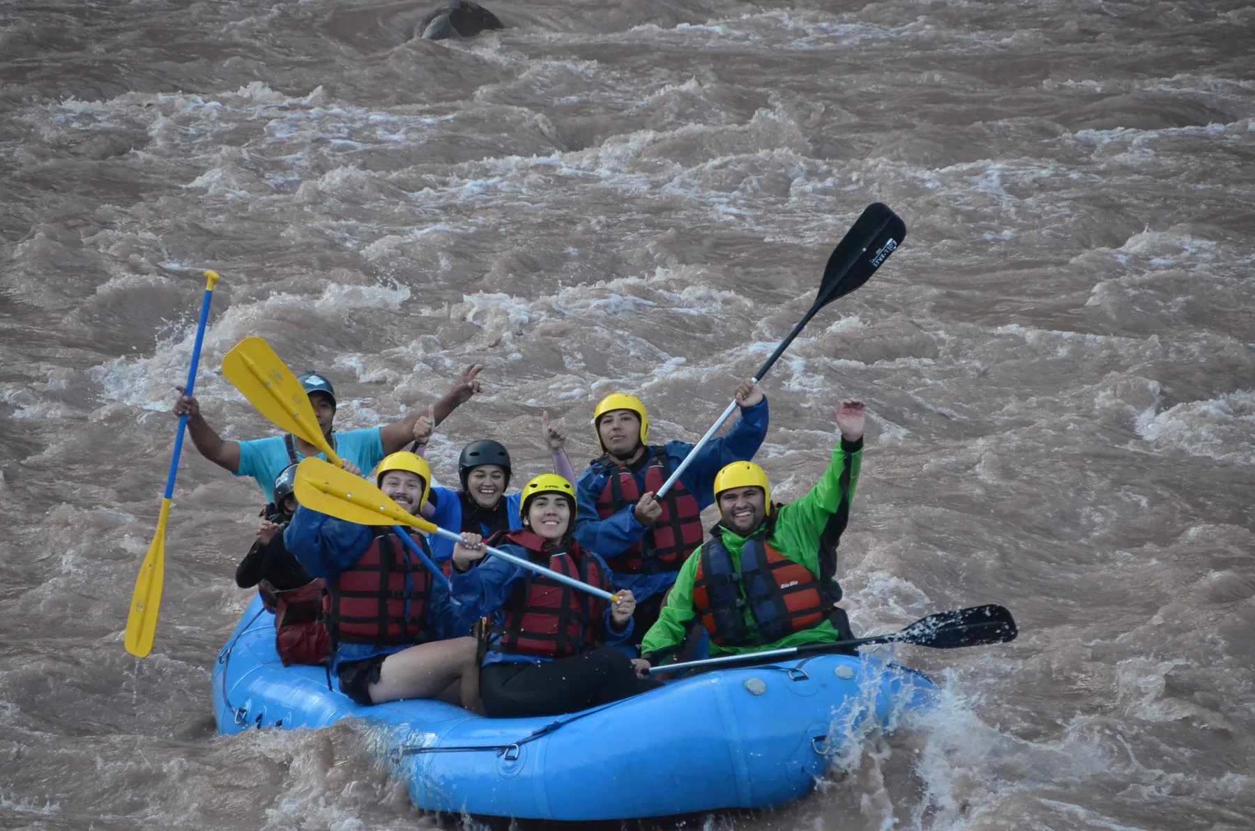Grupo de pasajeros celebra a bordo de la balsa en el río